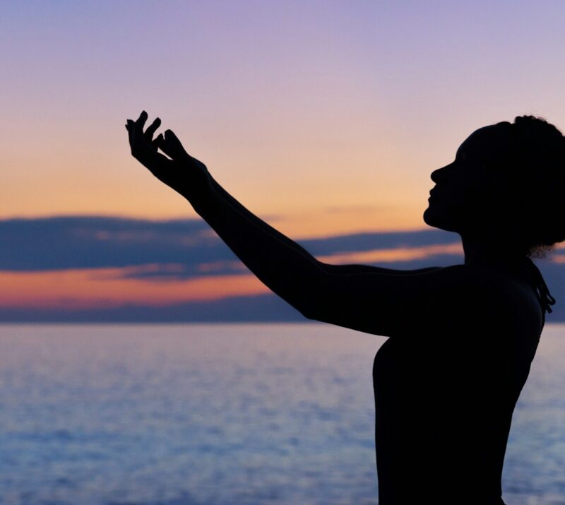 silhouette of woman raising her right hand